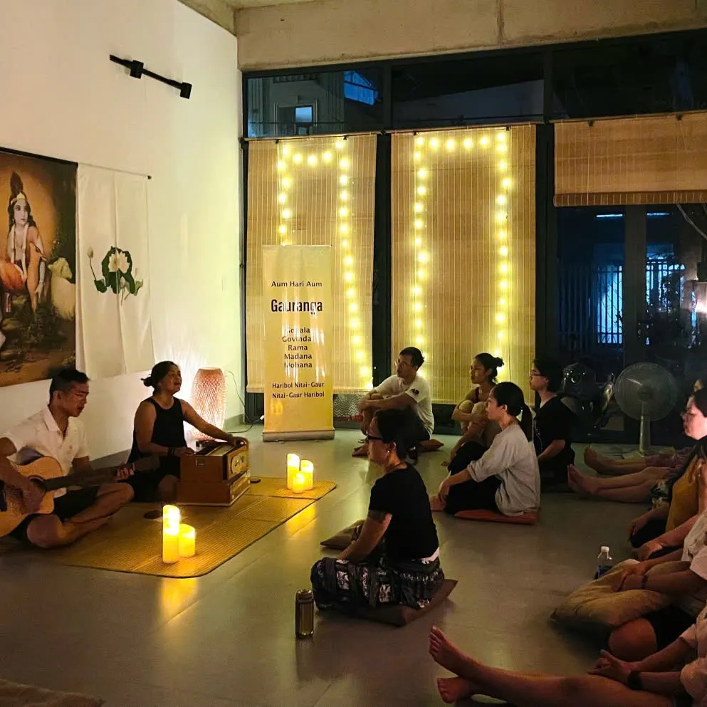 One person leading on a harmonium while the circle sings back.
