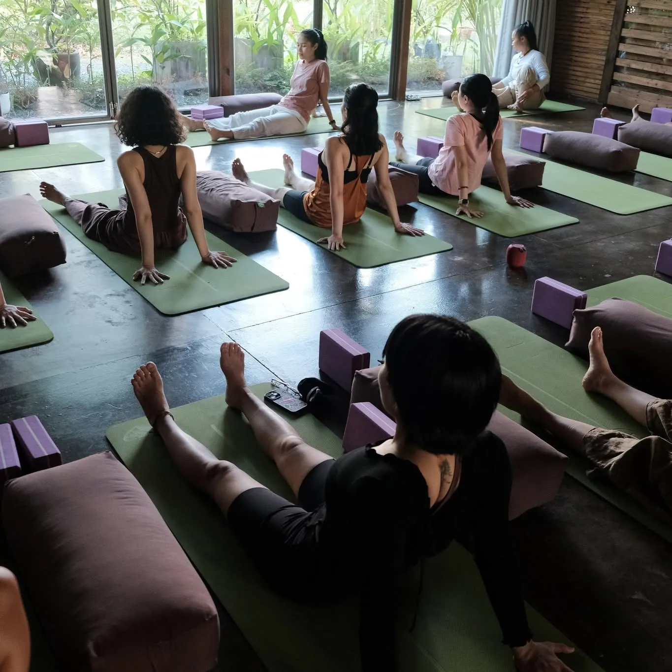 Mọi người nằm thư giãn trên thảm trong nhà gỗ sáng.