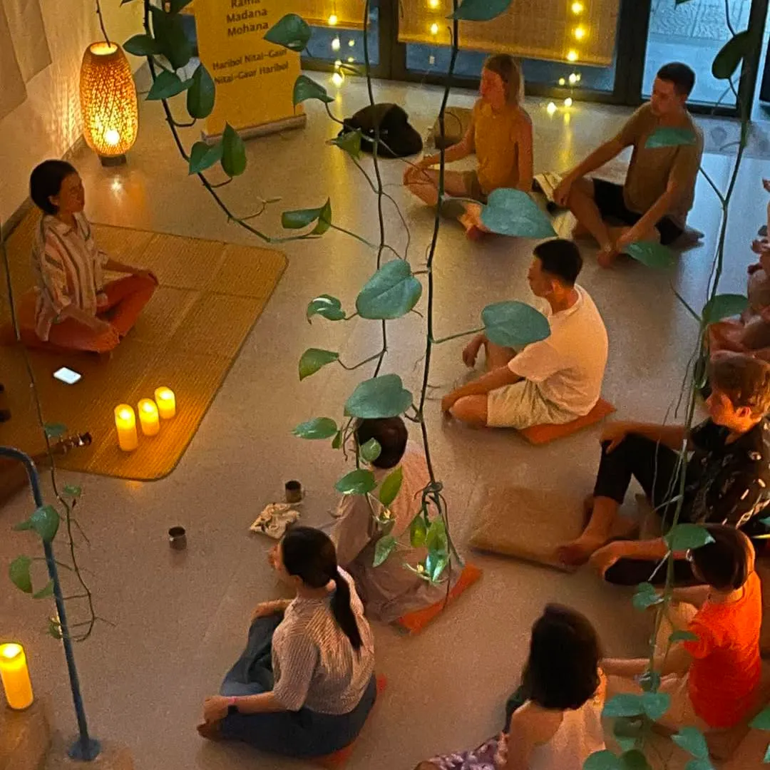 Mọi người ngồi thiền trên đệm quanh những ngọn nến.