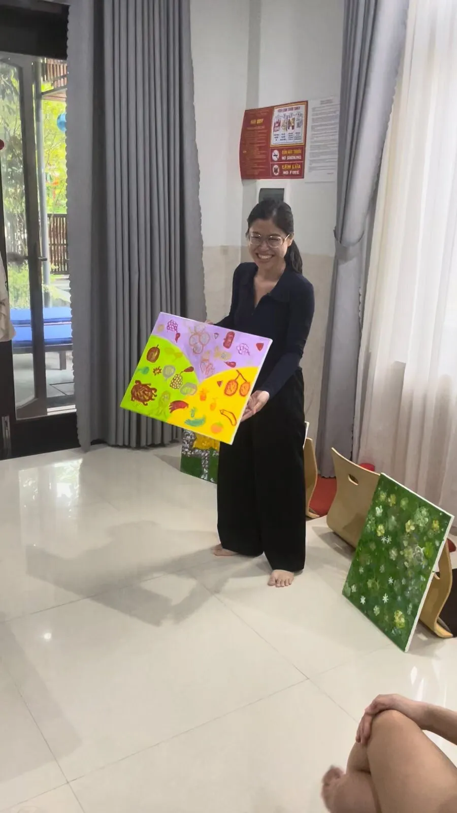 A member holding up the painting she has just finished.
