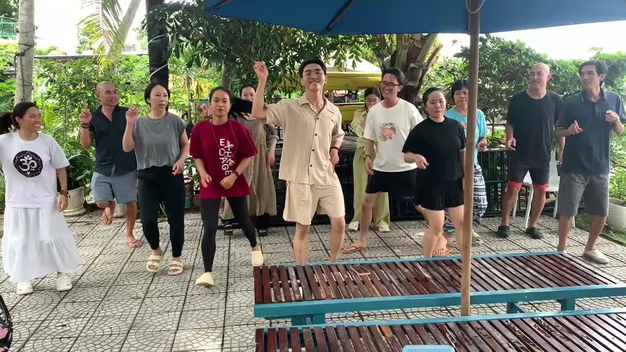 The group moving and laughing together in a garden.